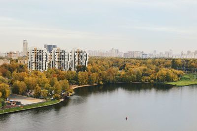 Scenic view of river by buildings against sky