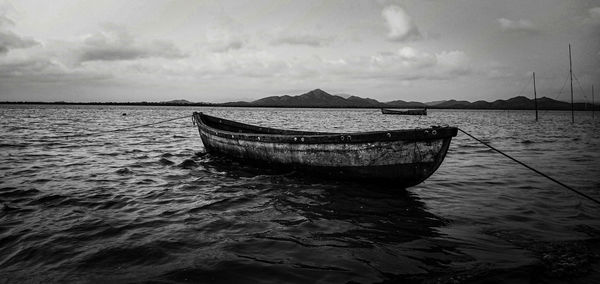 Boat moored in sea against sky