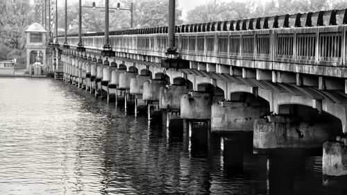 Wooden footbridge over river against sky