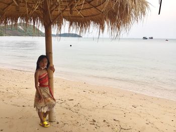 Rear view of woman standing at beach