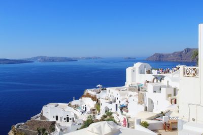 Buildings in sea against blue sky