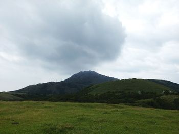 Scenic view of mountains against cloudy sky