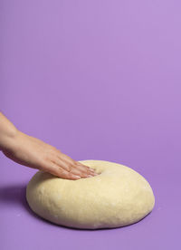 Close-up of hand against pink background