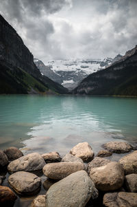 Scenic view of lake by mountains against sky