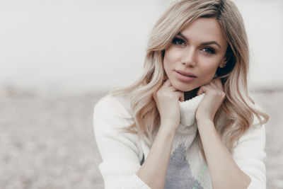 Portrait of young woman sitting at beach