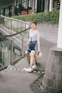 Tourist with luggage walking on footpath in city