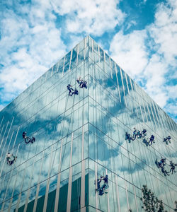 Low angle view of modern glass structure against sky