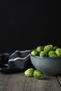 Bowl of brussels sprouts and napkin on a rustic wooden table.