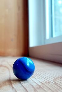 Close-up of blue ball on wooden table