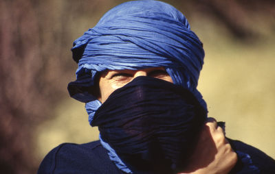 Close-up portrait of man covering face outdoors