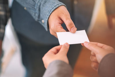 Close-up of businessman giving placard to colleague