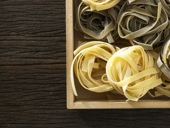 Directly above shot of tagliatelle pasta in crate on table