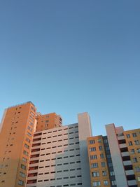 Low angle view of buildings against clear blue sky