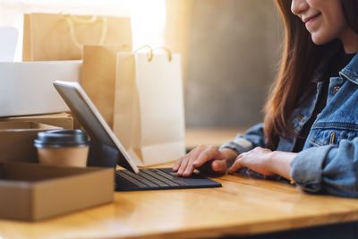 Midsection of woman using laptop on table