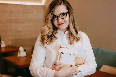 Portrait of young woman holding books