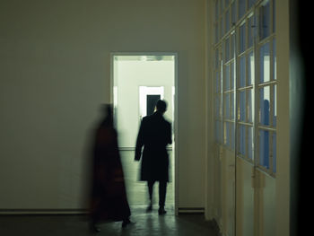 Rear view of man walking in corridor