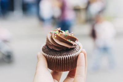 Close-up of hand holding cupcake