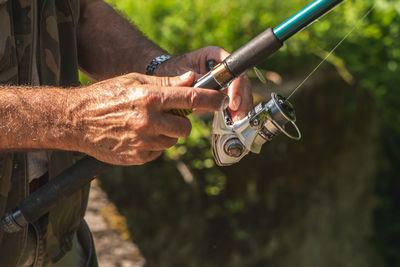 Close-up of man holding fishing stick