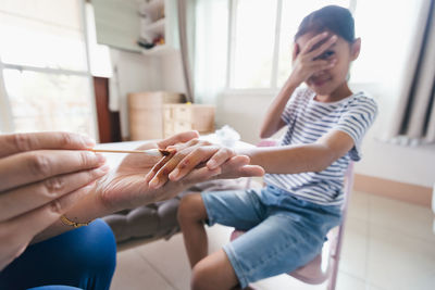 Asian child girl feeling scared while parent helping her perform first aid finger injury 