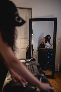 Fashionable young woman playing music at home