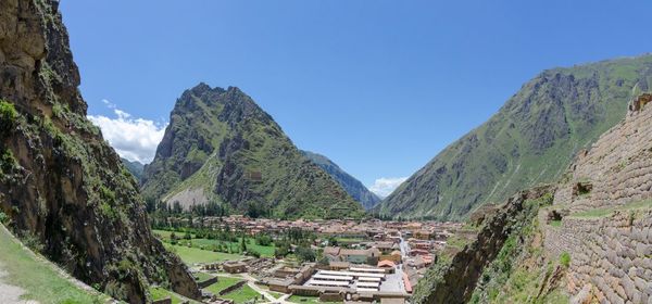 Panoramic view of mountains and inka ruins against clear blue sky