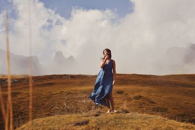 Full length of woman standing on landscape against sky