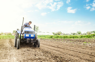 Farmer on a tractor with milling machine loosens, grinds and mixes soil.