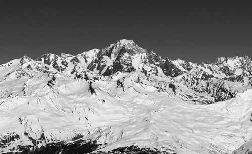 Scenic view of snowcapped mountains against clear sky