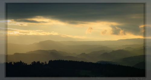 Scenic view of mountains against sky at sunset