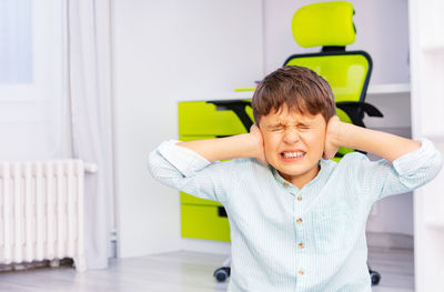 Boy closing ears at school