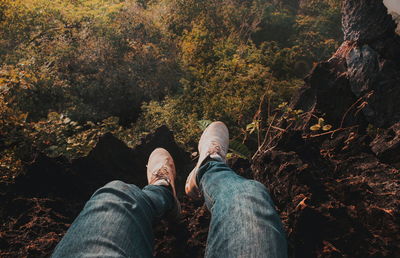 Low section of person sitting on cliff