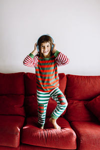 Portrait of boy wearing red sofa at home