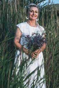 Girl with bright braids enjoys summer bliss in nature, holding a bouquet of flowers