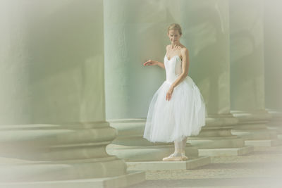 Young woman standing against wall