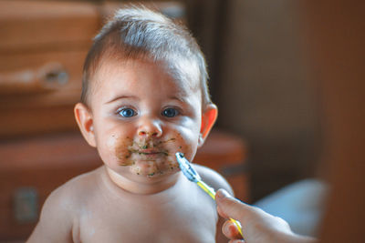 Cropped image of mother feeding cute toddler boy