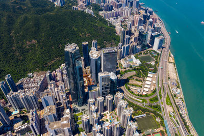 Aerial view of city by sea against sky