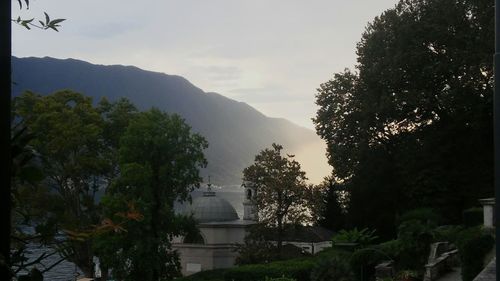 Silhouette trees by mountains against sky