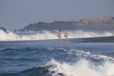 Man surfing in sea against sky