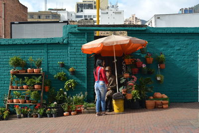 Rear view of man and woman standing against building