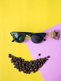 Close-up of sunglasses on table against yellow background