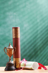 Close-up of trophy with diploma on desk