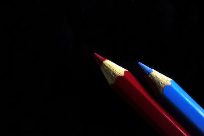Close-up of colored pencils against black background
