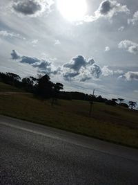 Road amidst field against sky