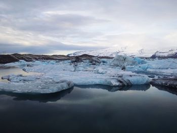 Close-up of glacier on sea against sky