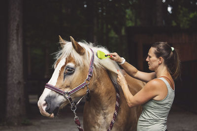 Side view of woman riding horse