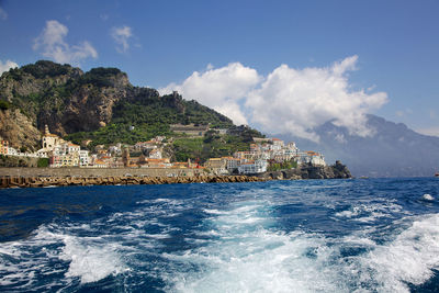 Scenic view of sea by buildings against sky