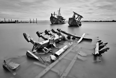 Abandoned boat on shore against sky