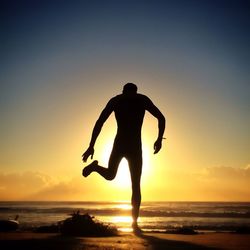 Silhouette of people on beach at sunset