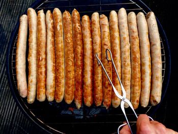 High angle view of human hand on barbecue grill