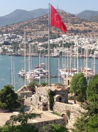 Scenic view of flag by city against mountains